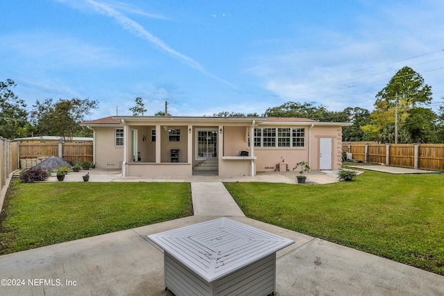 back of house featuring a lawn and a patio