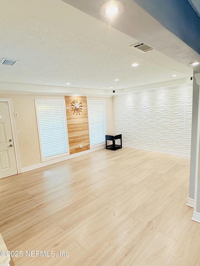 interior space with wood walls and light hardwood / wood-style flooring