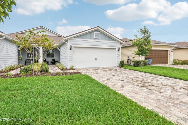 ranch-style house featuring a garage and a front lawn