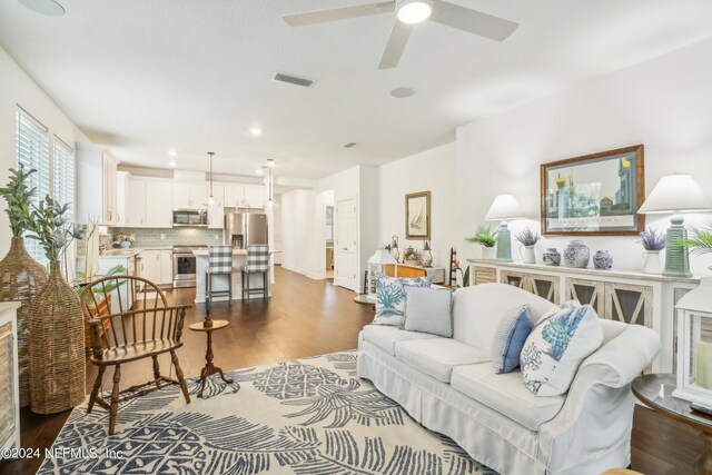 living room with dark hardwood / wood-style flooring and ceiling fan