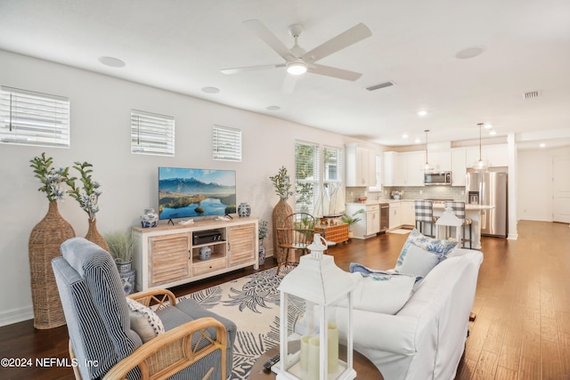 living room featuring dark hardwood / wood-style flooring and ceiling fan