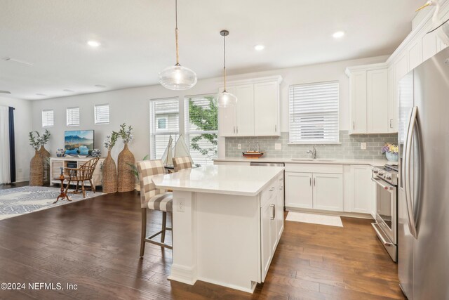 kitchen featuring decorative backsplash, sink, a center island, dark hardwood / wood-style floors, and appliances with stainless steel finishes