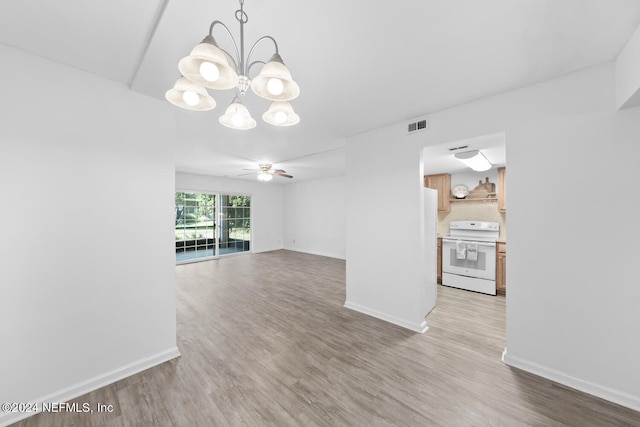 unfurnished living room with ceiling fan with notable chandelier and light wood-type flooring