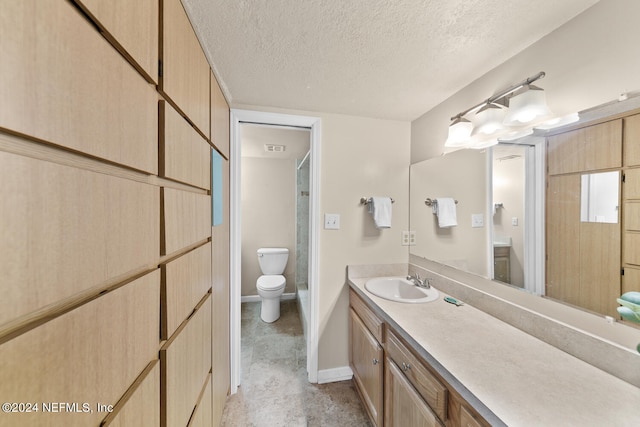 bathroom with vanity, a shower, toilet, and a textured ceiling