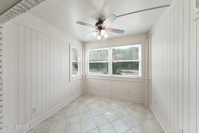 tiled spare room with ceiling fan