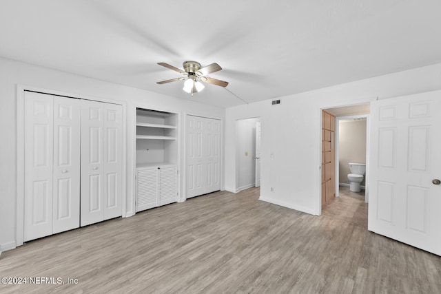 unfurnished bedroom featuring multiple closets, ceiling fan, and light wood-type flooring