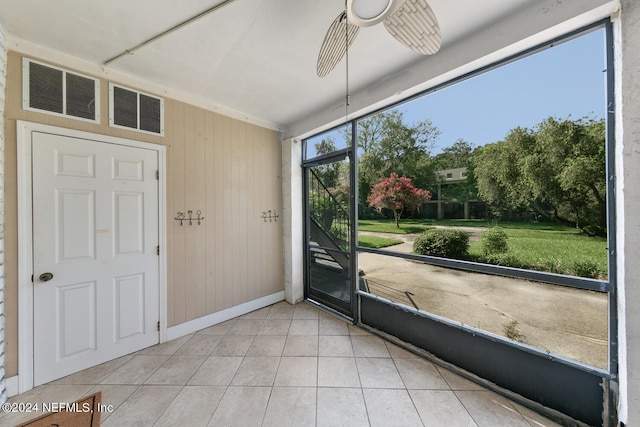 unfurnished sunroom with ceiling fan