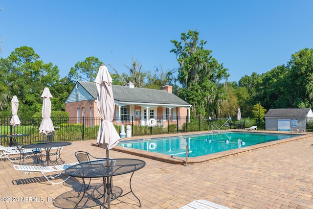 view of pool featuring an outbuilding and a patio area