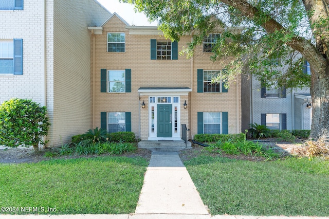 townhome / multi-family property with a front lawn