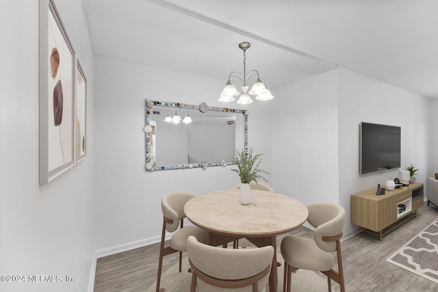 dining space featuring hardwood / wood-style flooring and a chandelier