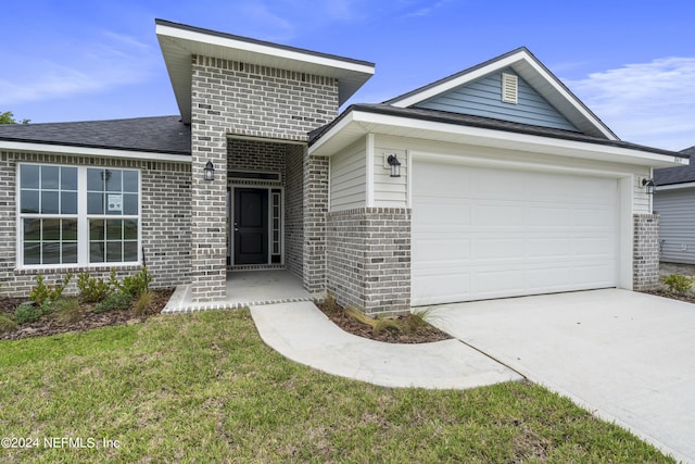 view of front of home with driveway, a garage, brick siding, roof with shingles, and a front yard