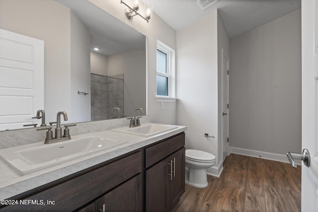 bathroom featuring vanity, toilet, hardwood / wood-style floors, and a shower