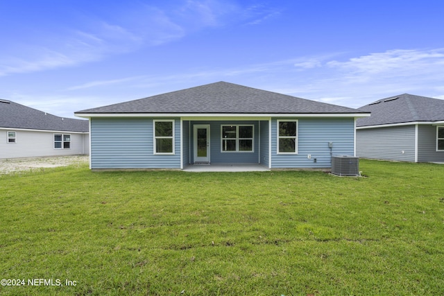 back of property featuring roof with shingles, a patio, cooling unit, and a yard