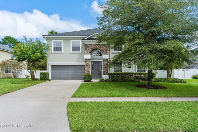 view of front of property featuring a front yard and a garage