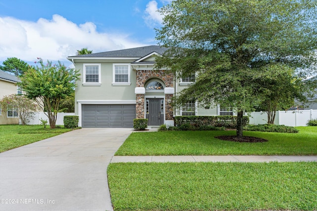 view of front of house with concrete driveway, stone siding, an attached garage, fence, and a front lawn