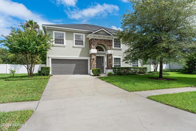 view of front of property featuring a garage and a front lawn