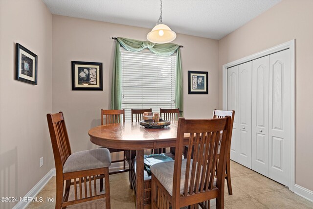 tiled dining space with a textured ceiling