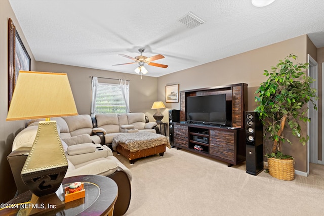 carpeted living room featuring ceiling fan and a textured ceiling