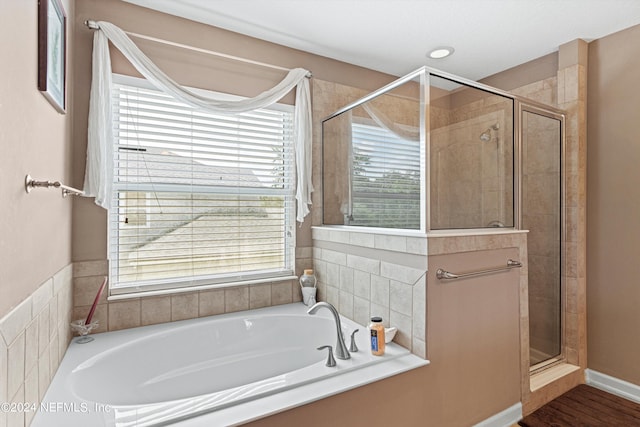 bathroom with plus walk in shower, wood-type flooring, and a wealth of natural light