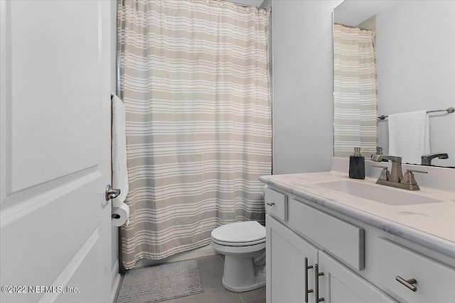 bathroom with toilet, tile patterned floors, and vanity