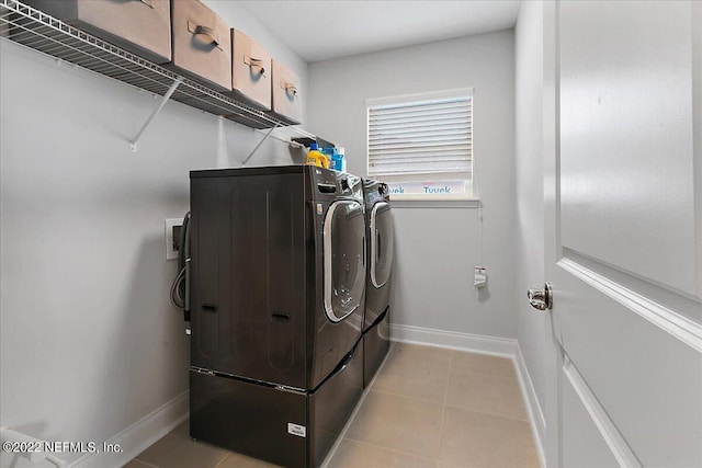 laundry room featuring cabinets, light tile patterned floors, and independent washer and dryer