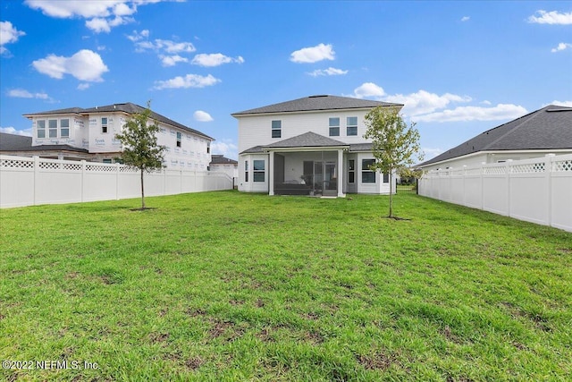 back of house featuring a lawn and a sunroom