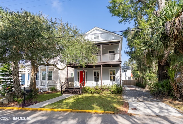 view of front of property featuring a balcony, a front yard, and a porch