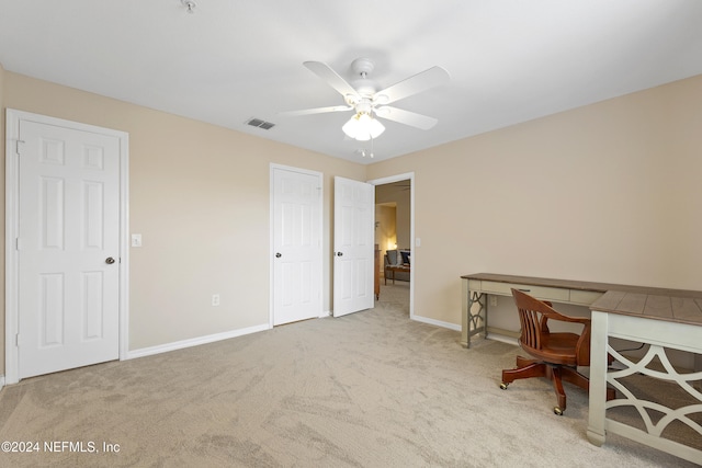 unfurnished office with ceiling fan and light colored carpet