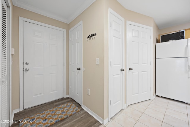 entrance foyer with ornamental molding and light hardwood / wood-style flooring