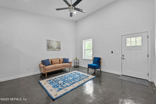 interior space with ceiling fan, a healthy amount of sunlight, and a high ceiling