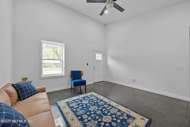 living room featuring ceiling fan and a towering ceiling