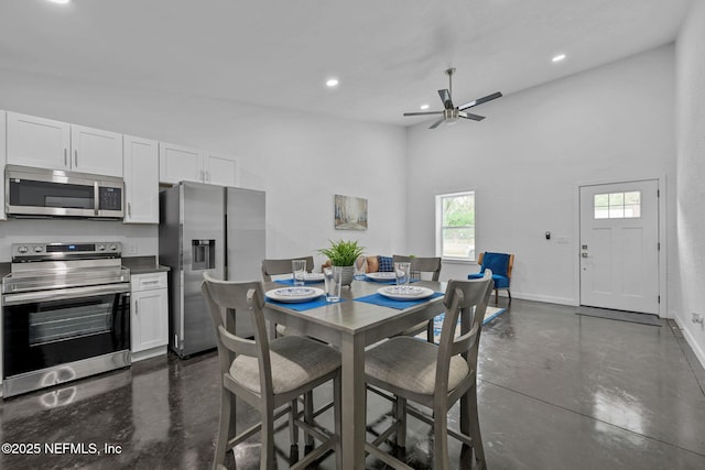 dining area featuring ceiling fan and a towering ceiling