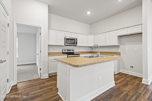 kitchen with stainless steel appliances, an island with sink, sink, and white cabinetry