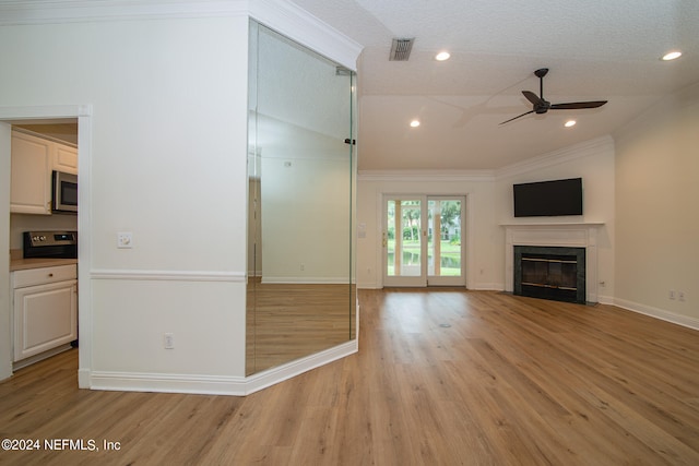 unfurnished living room featuring light hardwood / wood-style flooring, a textured ceiling, lofted ceiling, ornamental molding, and ceiling fan