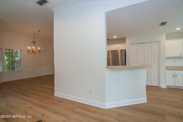 kitchen featuring white cabinets, a chandelier, high quality fridge, and light hardwood / wood-style floors