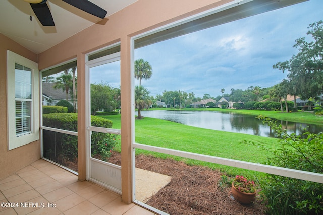 unfurnished sunroom with a water view and ceiling fan