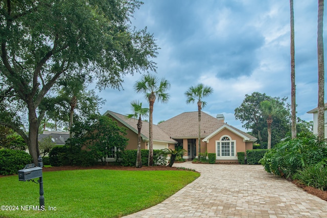 view of front of property with a front lawn and a garage