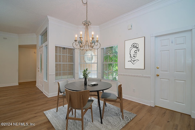 dining area with an inviting chandelier, ornamental molding, and wood-type flooring