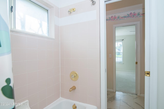 bathroom featuring tile patterned floors and tiled shower / bath