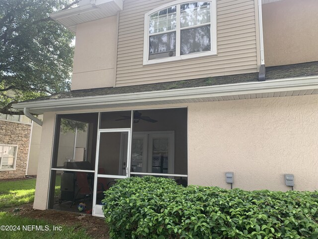 rear view of property featuring a sunroom