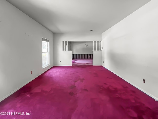 unfurnished living room with carpet flooring and baseboards