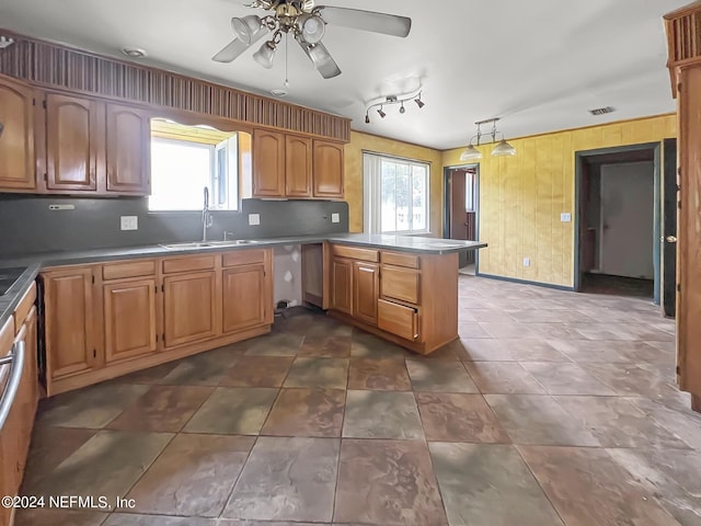 kitchen featuring a peninsula, a wealth of natural light, tasteful backsplash, and a sink