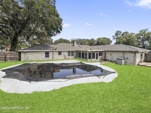 back of property with a yard, brick siding, fence, and a sunroom