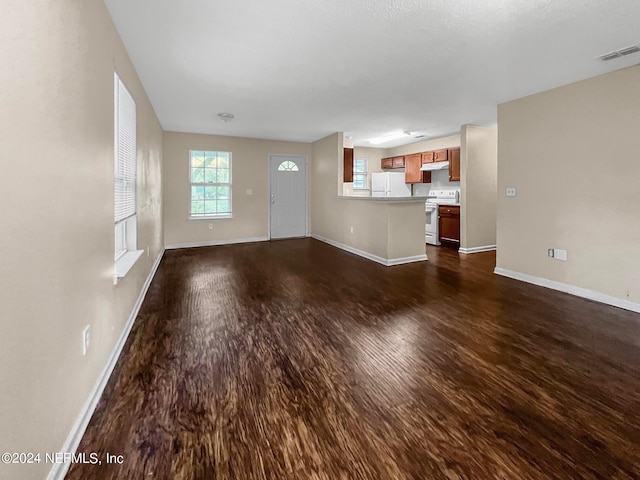 unfurnished living room with dark wood-type flooring