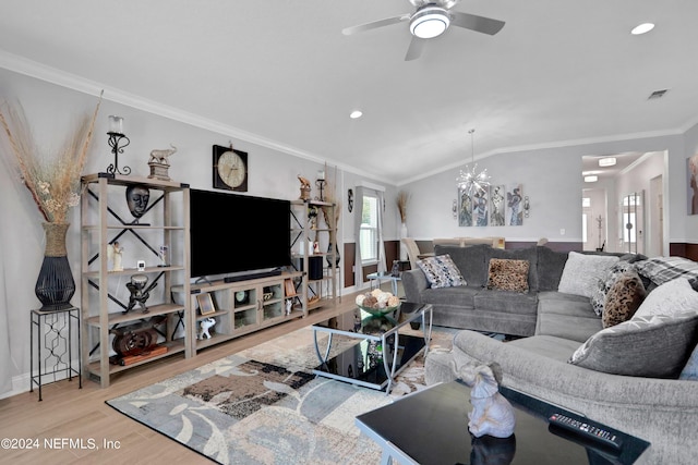 living room with ceiling fan with notable chandelier, ornamental molding, lofted ceiling, and hardwood / wood-style floors