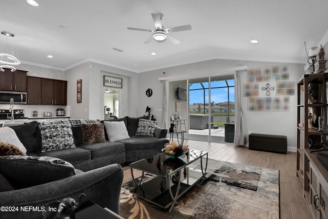 living room featuring lofted ceiling, sink, crown molding, light hardwood / wood-style flooring, and ceiling fan