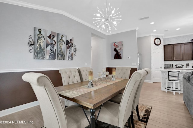 dining area featuring crown molding, lofted ceiling, a notable chandelier, and light hardwood / wood-style flooring