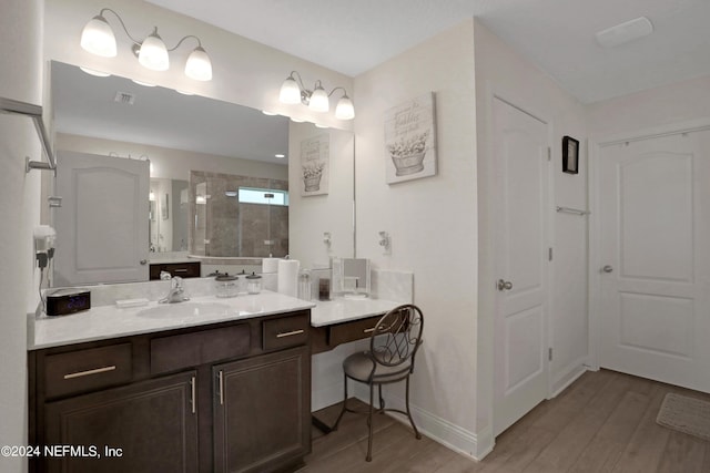 bathroom with hardwood / wood-style flooring, vanity, and an enclosed shower