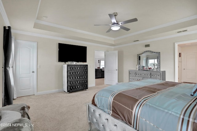 carpeted bedroom with ceiling fan, ornamental molding, and a tray ceiling