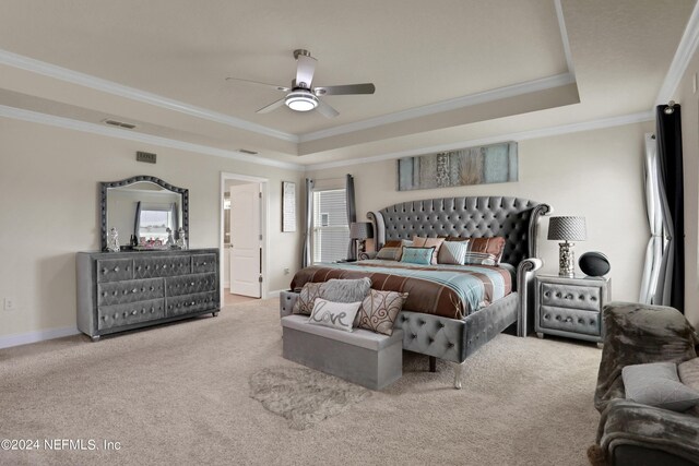 carpeted bedroom featuring crown molding, ceiling fan, and a raised ceiling